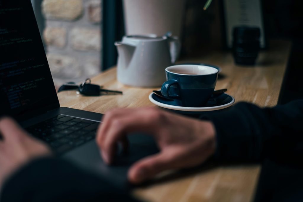Persona al lavoro con laptop in un caffè a Milano